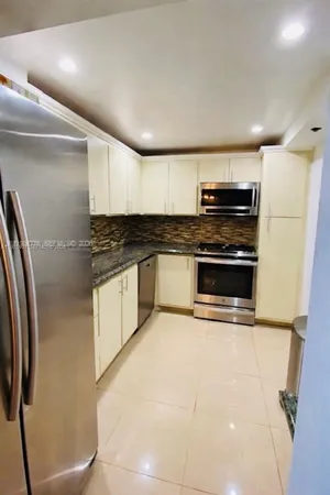 a kitchen with stainless steel appliances and a counter top space