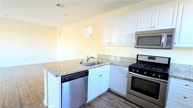 a kitchen with granite countertop a stove and a microwave