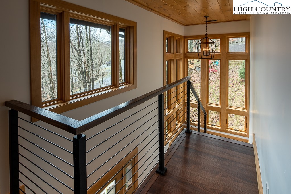 102 Ski Beech Road Beech Mountain, NC 28604 - Photo 11 of 40 a view of a hallway with wooden floor and windows