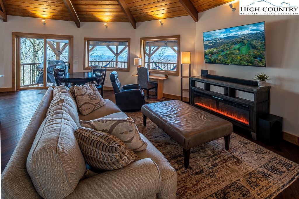 102 Ski Beech Road Beech Mountain, NC 28604 - Photo 13 of 40 a living room with furniture a flat screen tv and floor to ceiling windows