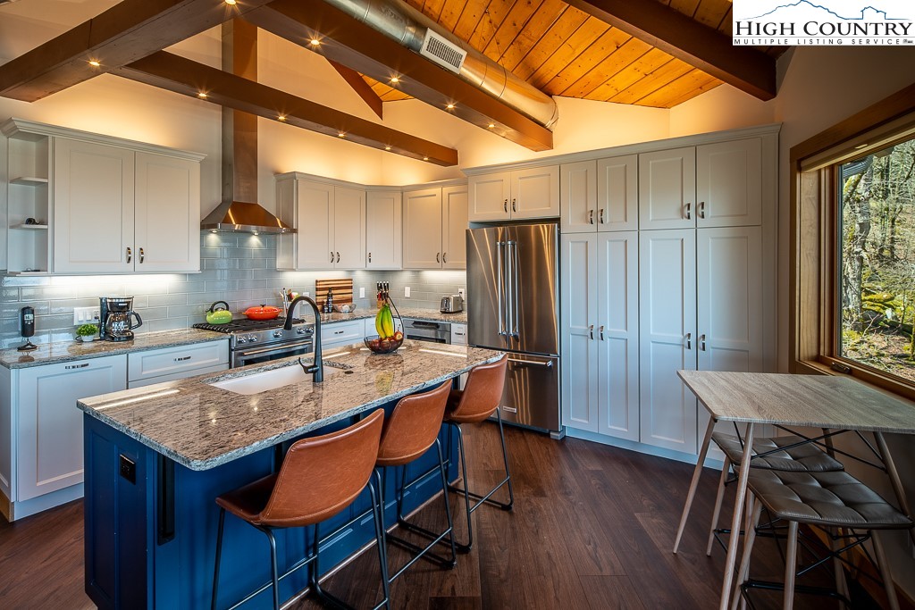 102 Ski Beech Road Beech Mountain, NC 28604 - Photo 16 of 40 a kitchen with a table chairs refrigerator and cabinets