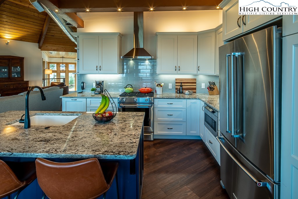 102 Ski Beech Road Beech Mountain, NC 28604 - Photo 17 of 40 a kitchen with stainless steel appliances granite countertop a refrigerator a stove and a wooden floors