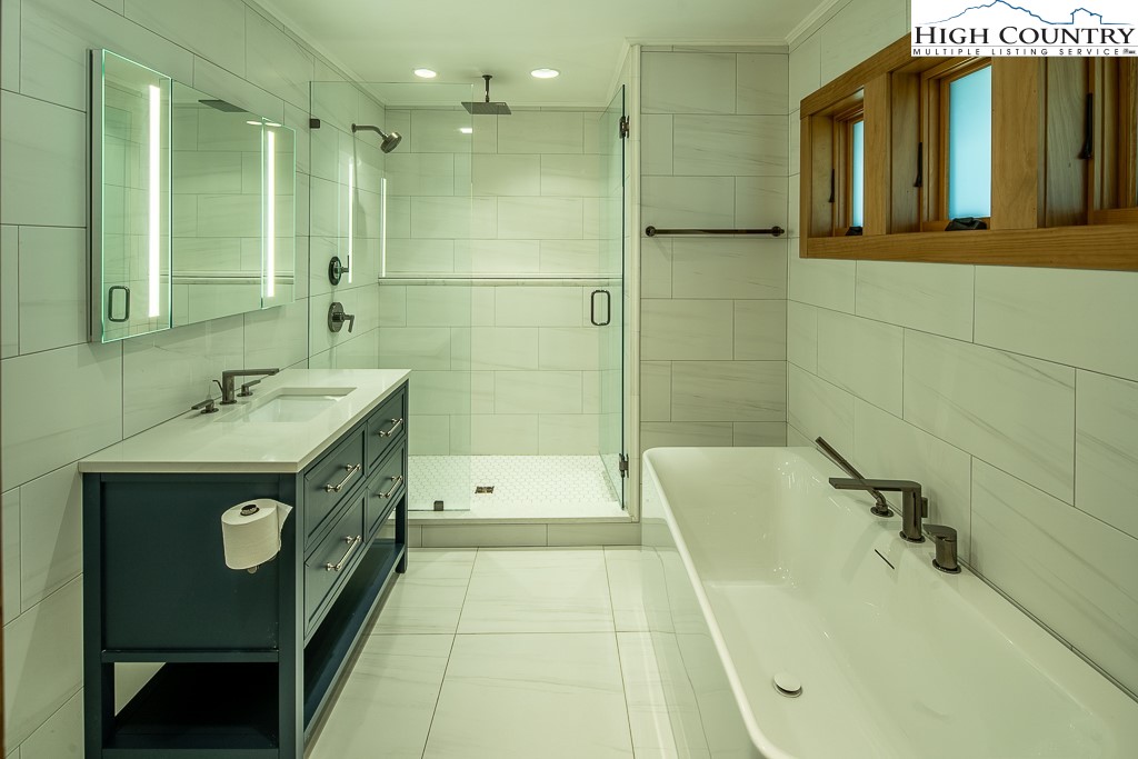 102 Ski Beech Road Beech Mountain, NC 28604 - Photo 21 of 40 a bathroom with a tub sink shower and mirror