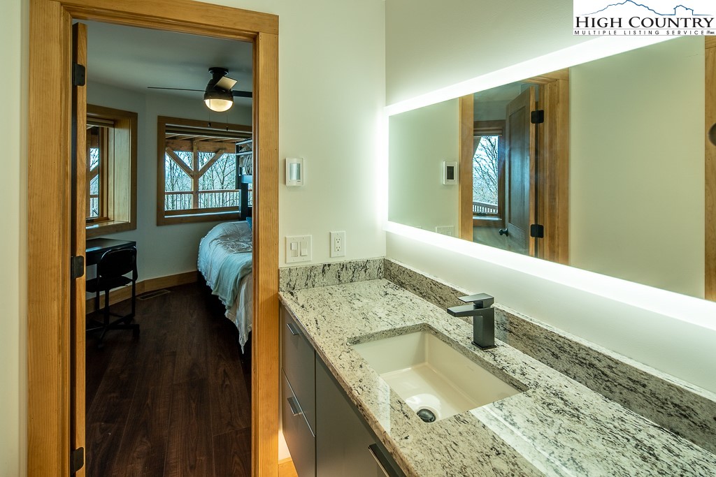 102 Ski Beech Road Beech Mountain, NC 28604 - Photo 28 of 40 a bathroom with a granite countertop sink and a large mirror