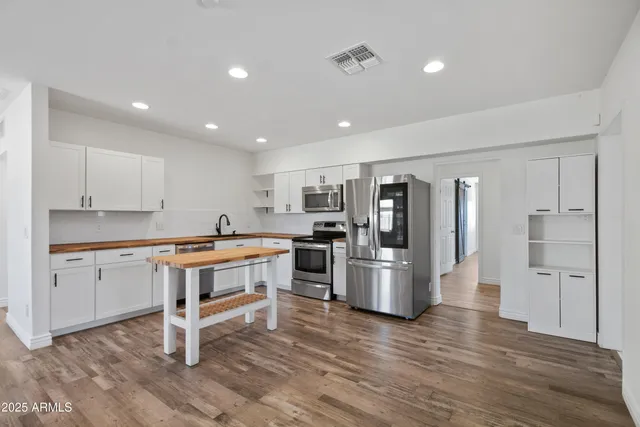 a kitchen with refrigerator and cabinets