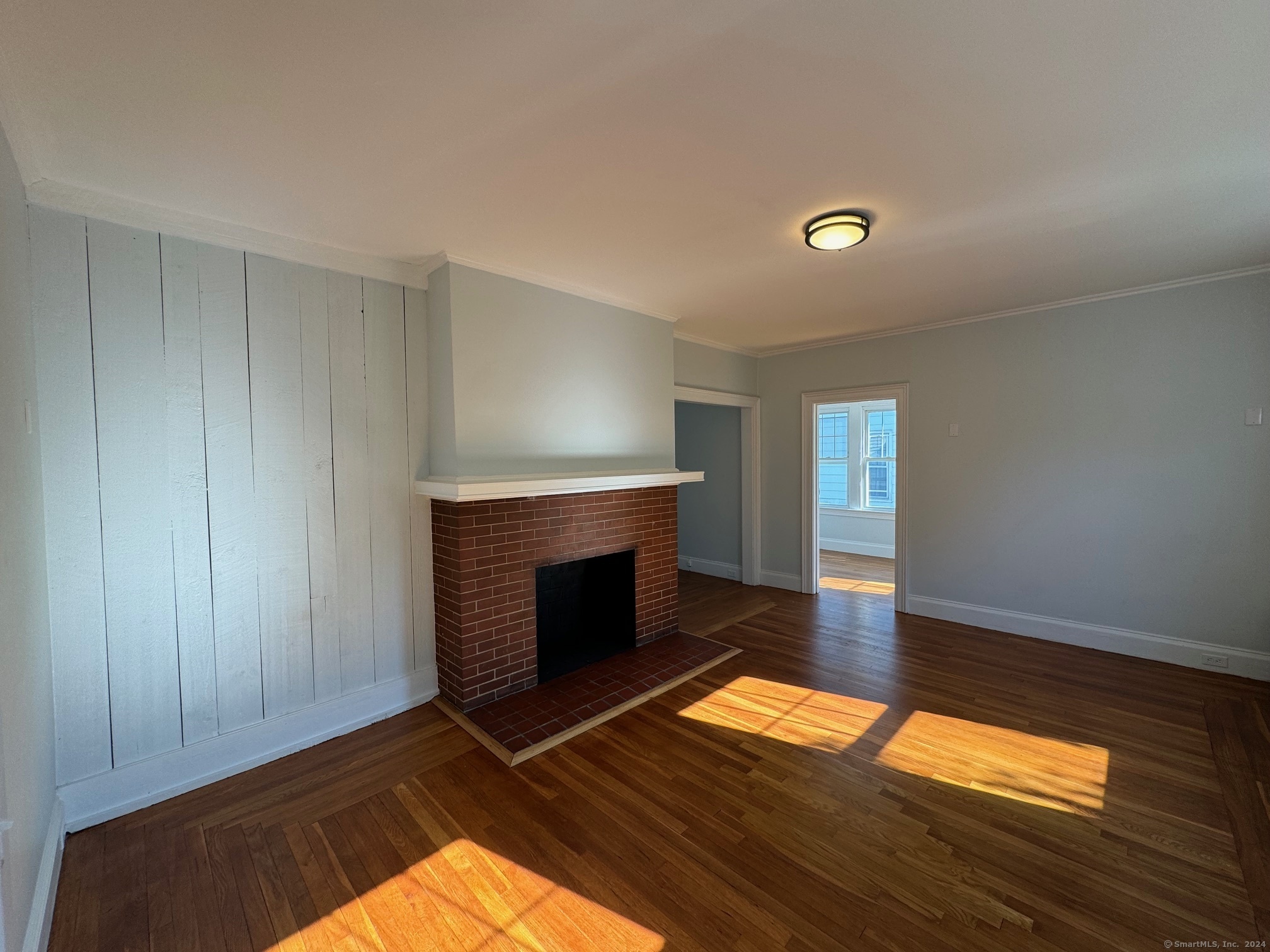 1253 Forest Road, Unit 2 New Haven, CT 06515 - Photo 11 of 30 a view of empty room with wooden floor and fireplace