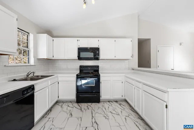 a kitchen with granite countertop a sink stove top oven and cabinets