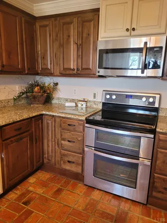 a kitchen with granite countertop a stove microwave and cabinets