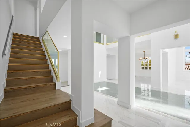 a view of a hallway with wooden floor and staircase