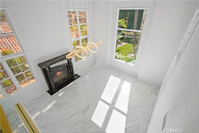 a view of an empty room with wooden floor and a fireplace