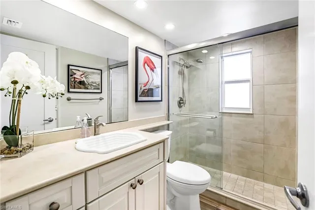 a bathroom with a granite countertop sink toilet and shower