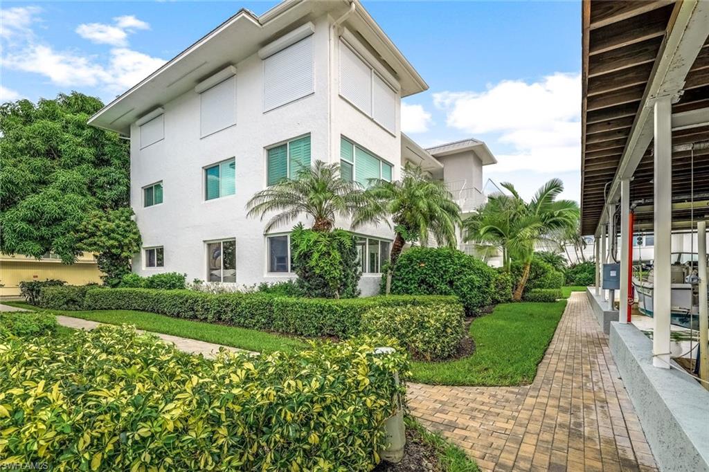 1100 8th Avenue South, Unit H227 Naples, FL 34102 - Photo 19 of 22 a front view of a house with a yard