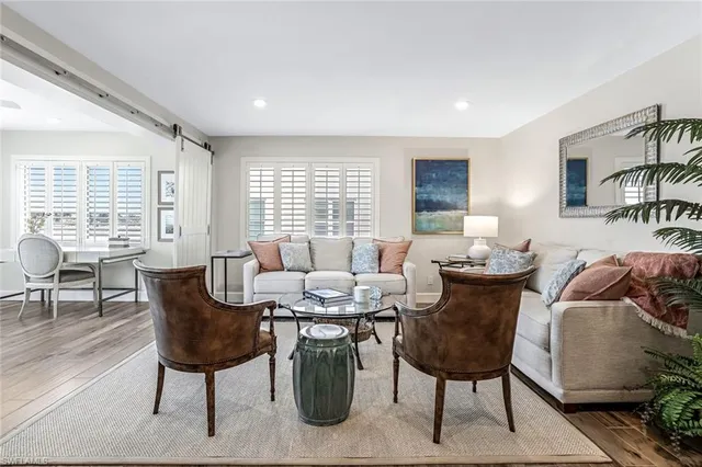 a living room with furniture two window and a table