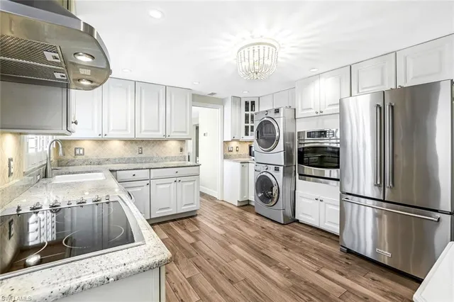 a kitchen with refrigerator a stove a sink and cabinets