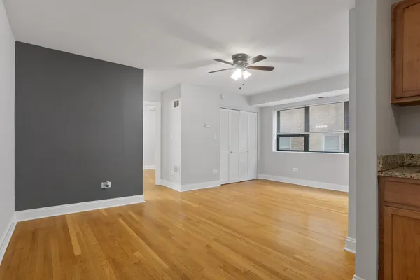 a view of empty room with window and ceiling fan