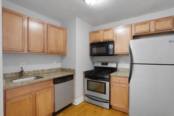 a kitchen with granite countertop a refrigerator stove and microwave