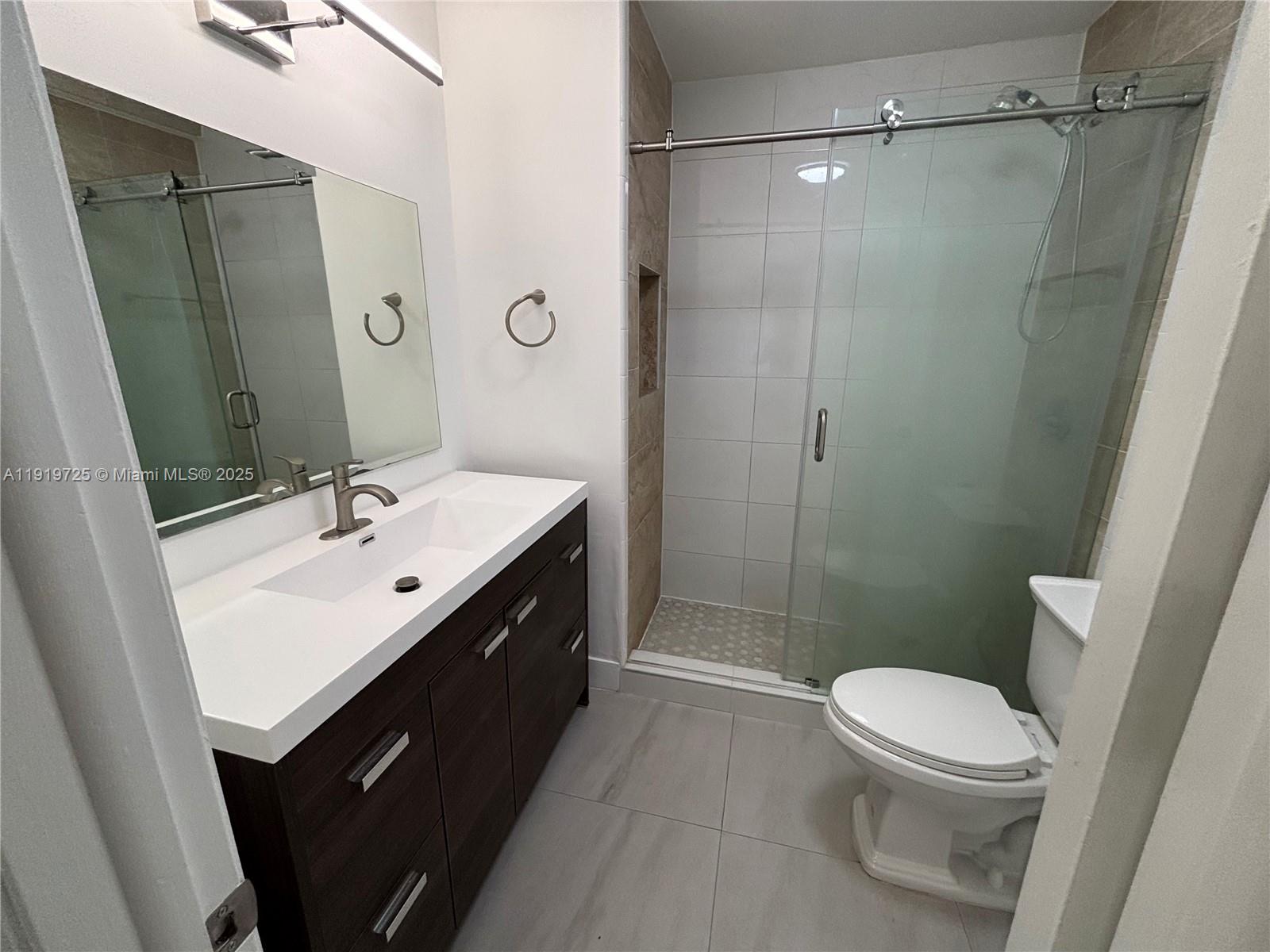 3616 Southwest 17th Street, Unit 3616 Miami, FL 33145 - Photo 5 of 16 a bathroom with a sink a toilet a mirror and shower