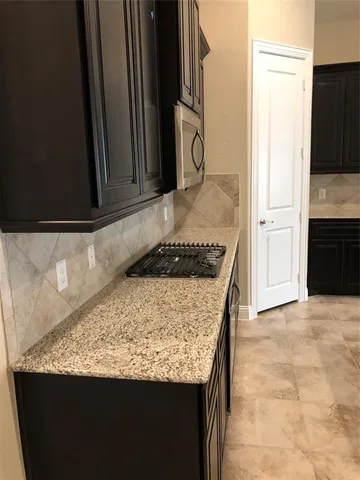 a kitchen with granite countertop sink and cabinets