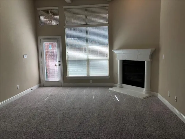 an empty room with a fireplace and windows