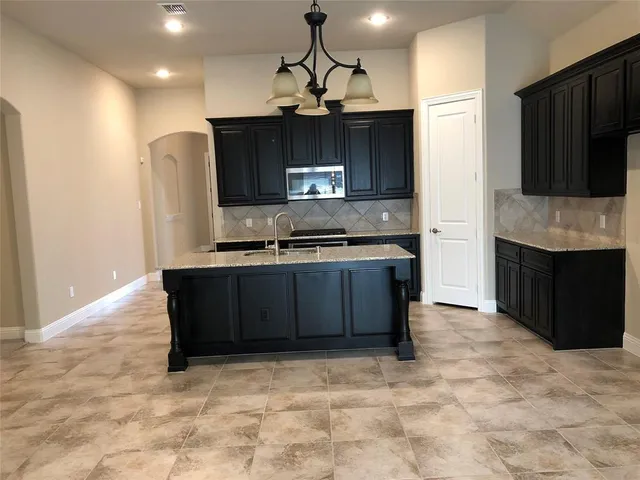 a kitchen with stainless steel appliances granite countertop a stove and a refrigerator