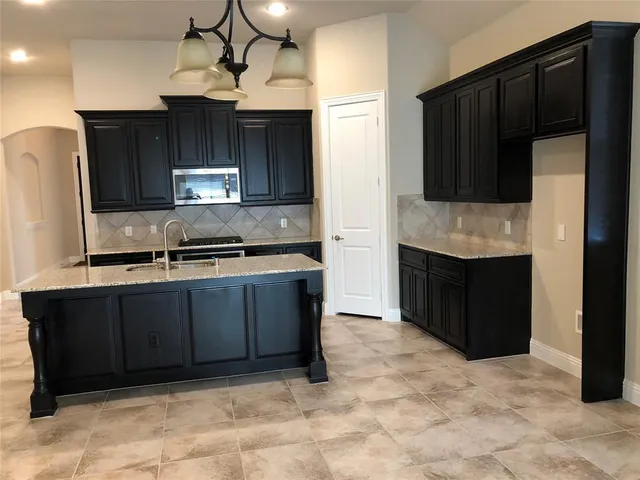 a kitchen with stainless steel appliances granite countertop a refrigerator and a wooden cabinets