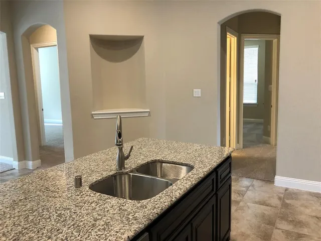a kitchen with a sink and a wooden floor