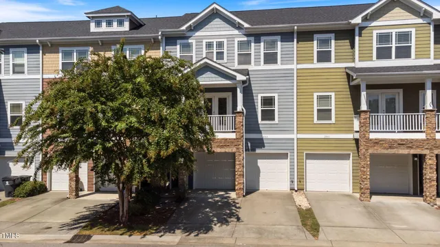 a front view of a house with a tree