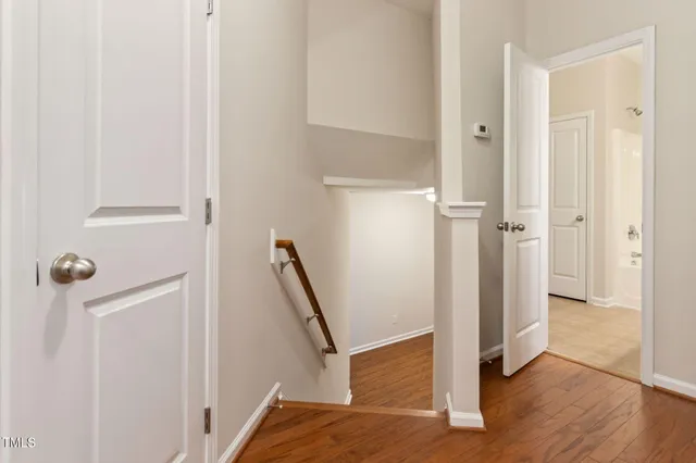 a view of an empty room with wooden floor fireplace and a window
