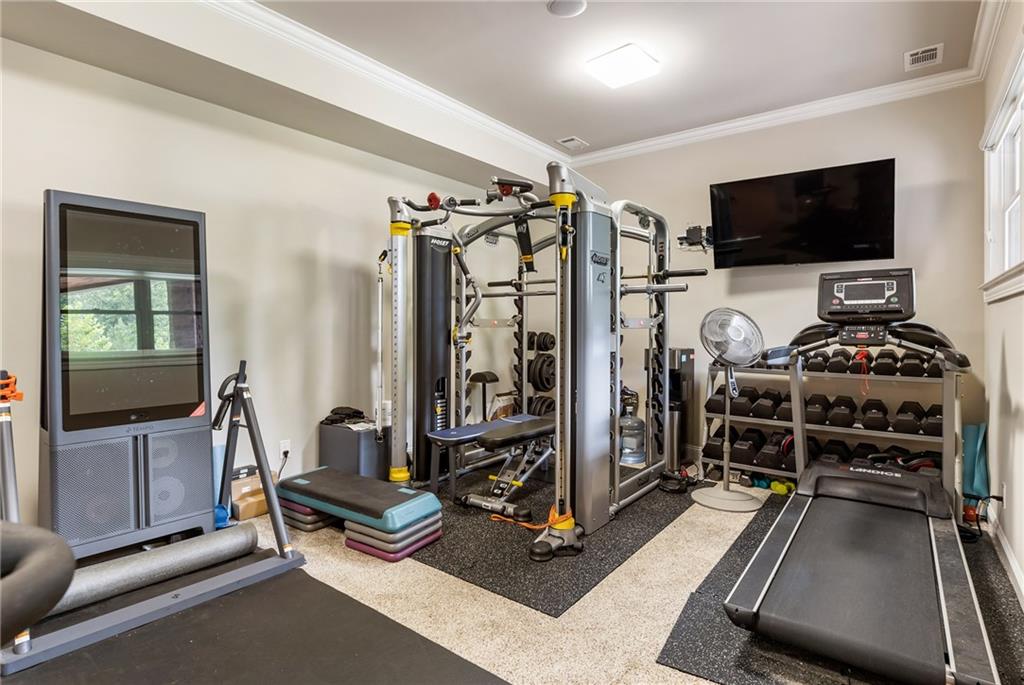 14560 Wood Road Milton, GA 30004 - Photo 51 of 74 a living room with gym equipment and a flat screen tv