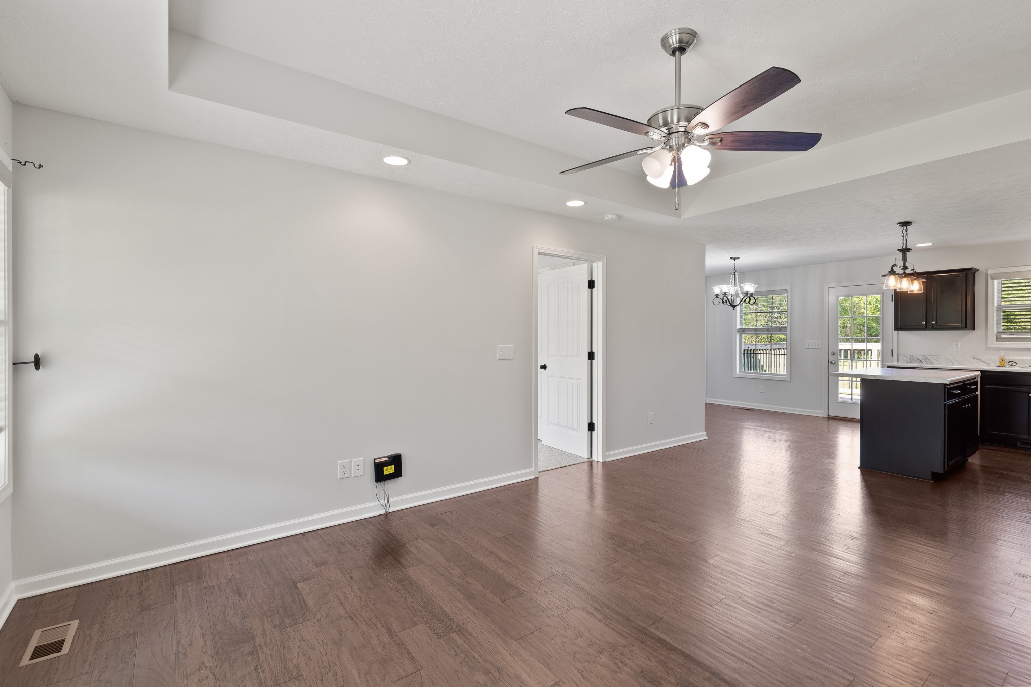 1821 Rock Bridge Road Bethpage, TN 37022 - Photo 7 of 31 an empty room with wooden floor chandelier fan and windows