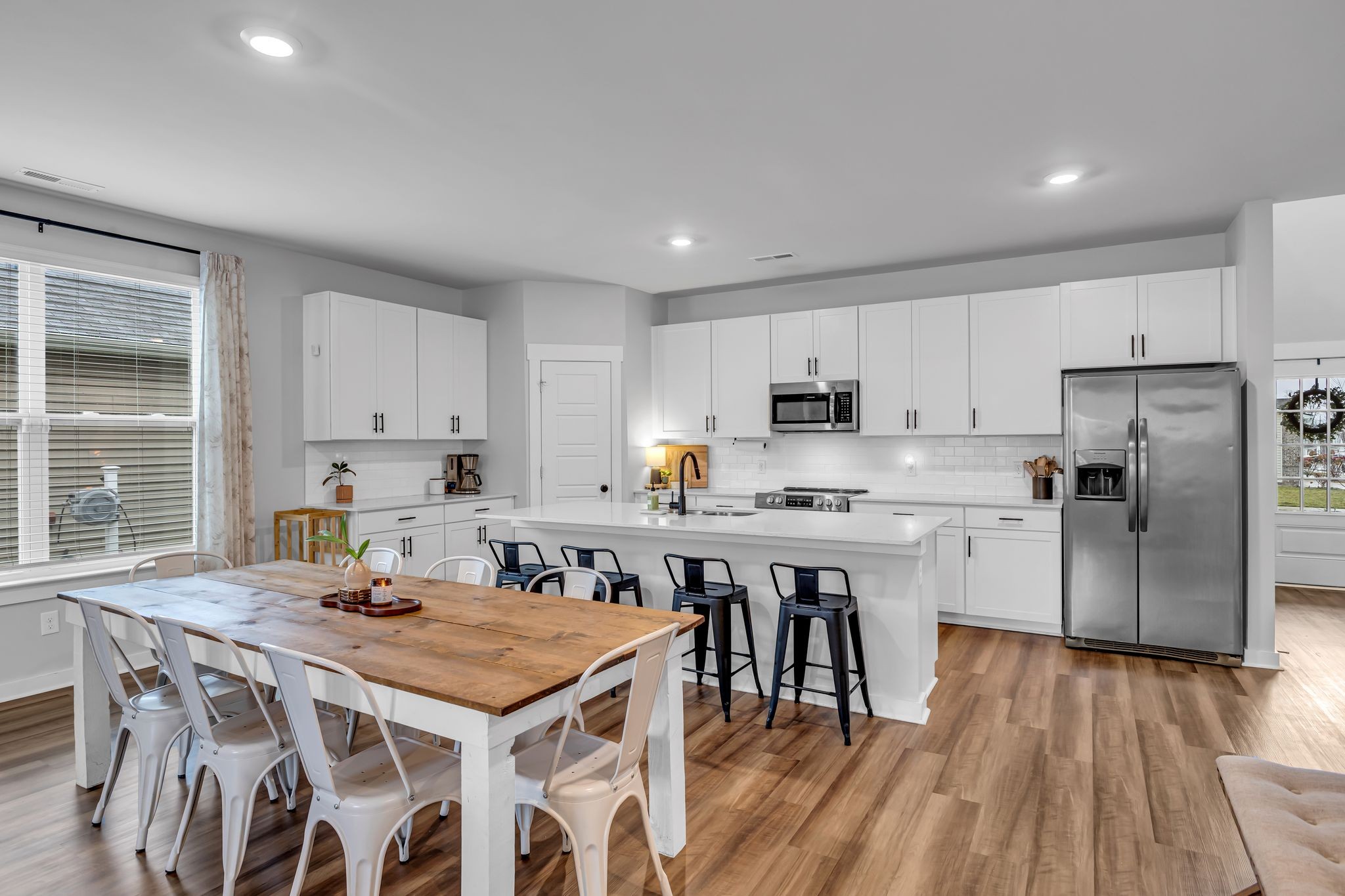 417 Irwin Way Spring Hill, TN 37174 - Photo 14 of 43 a kitchen with a table chairs a sink dishwasher a refrigerator and cabinets with wooden floor
