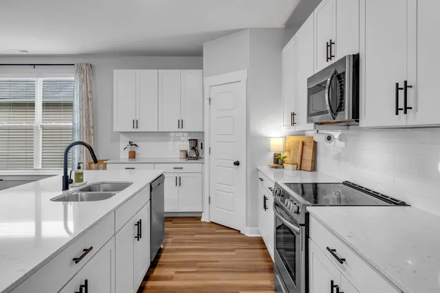 a kitchen with granite countertop a sink stainless steel appliances and cabinets