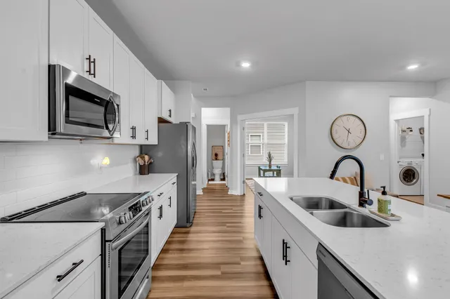 a kitchen with stainless steel appliances granite countertop a white stove top oven a sink and dishwasher