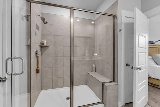 a bathroom with a shower and a sink a mirror