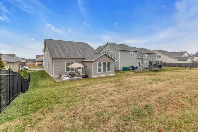 a view of a big house with a big yard and large trees