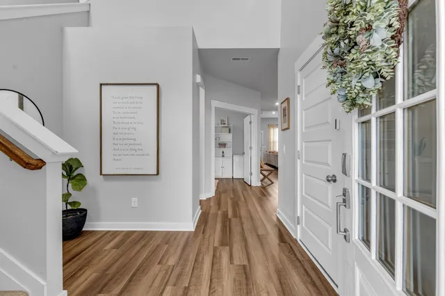 a view of a hallway with wooden floor and staircase