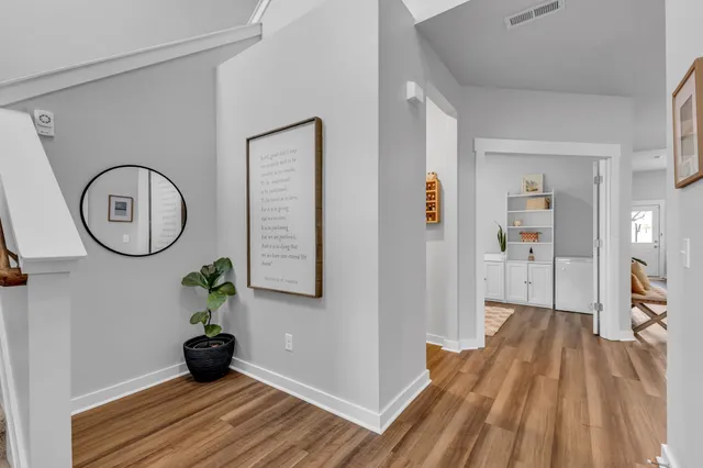 a view of a room with wooden floor and a ceiling fan