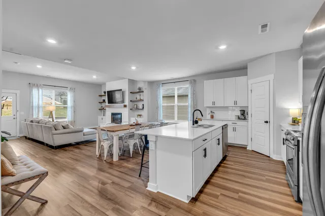 a large white kitchen with lots of counter top space and furniture