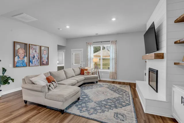 a living room with furniture a fireplace and a large window