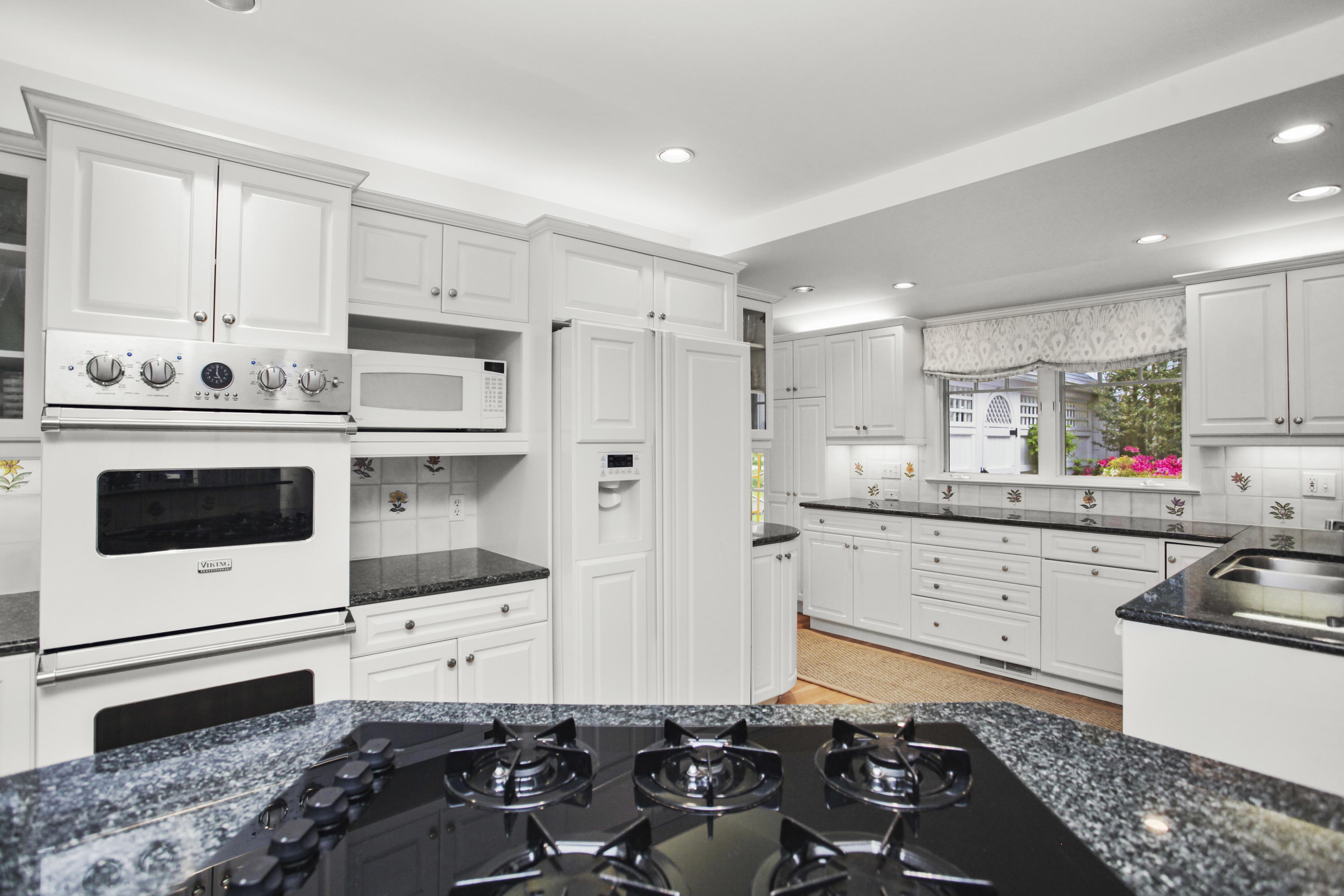 40 Birch Road Darien, CT 06820 - Photo 21 of 40 a kitchen with a sink stove and white cabinets