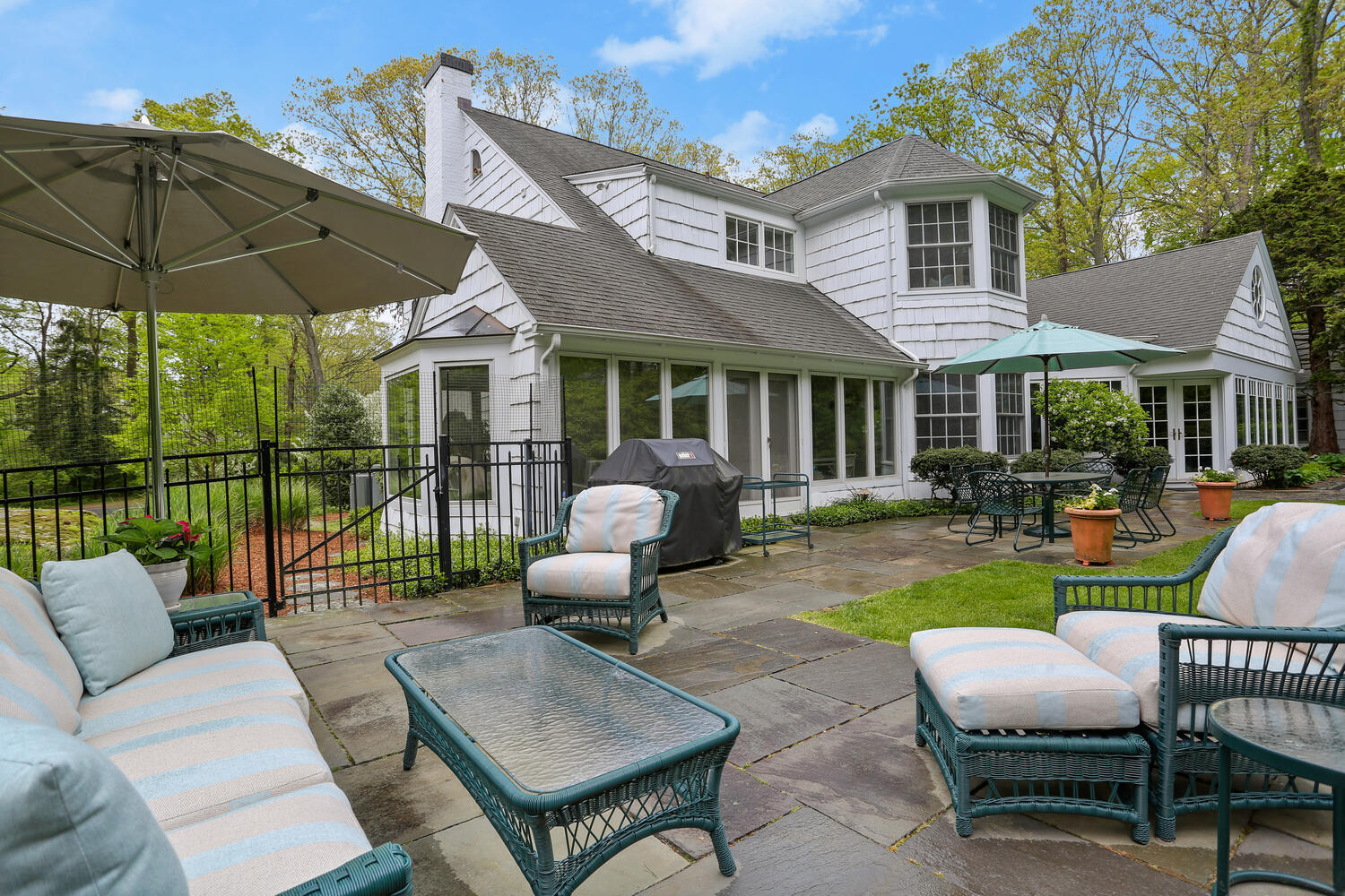 40 Birch Road Darien, CT 06820 - Photo 10 of 40 a view of a patio with couches chairs and a table and chairs under an umbrella