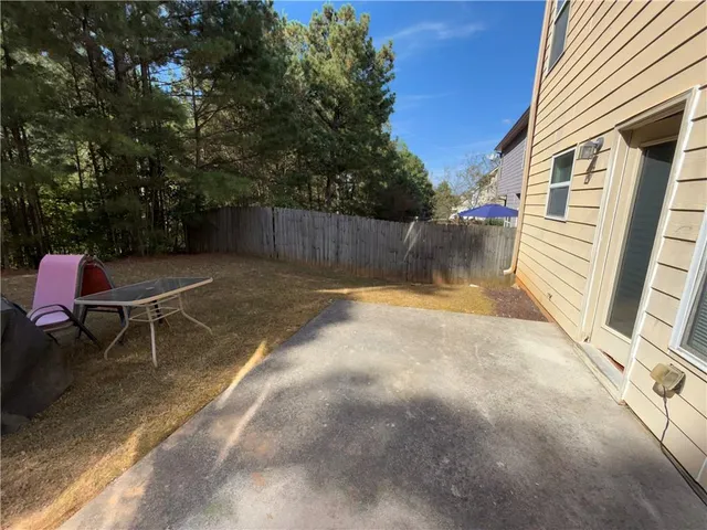 a view of a patio with table and chairs and potted plants with wooden floor and fence