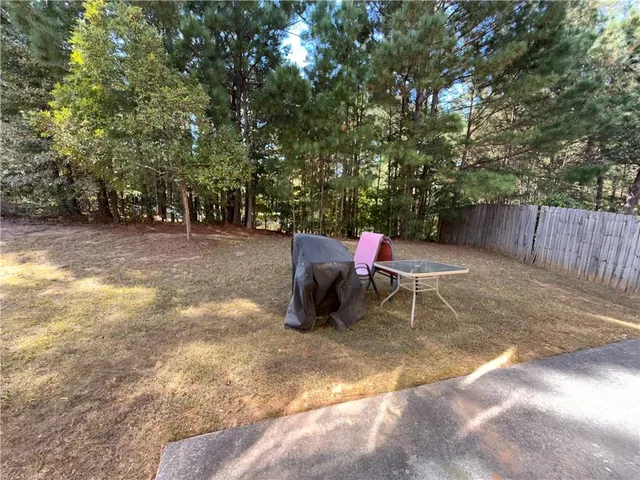 a backyard of a house with table and chairs