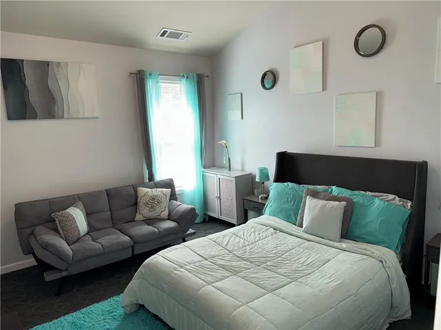 a bedroom with bed couch and window