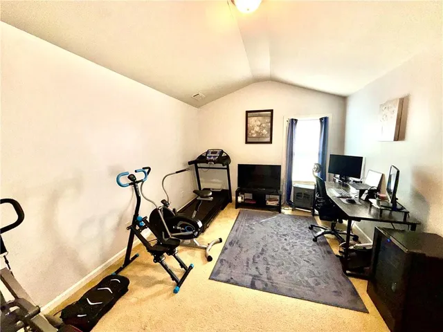 a living room with furniture a flat screen tv and a wooden floor