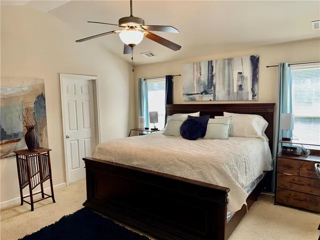 a bedroom with a bed and dresser with wooden floor