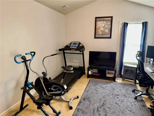a room with gym equipment and a flat screen tv