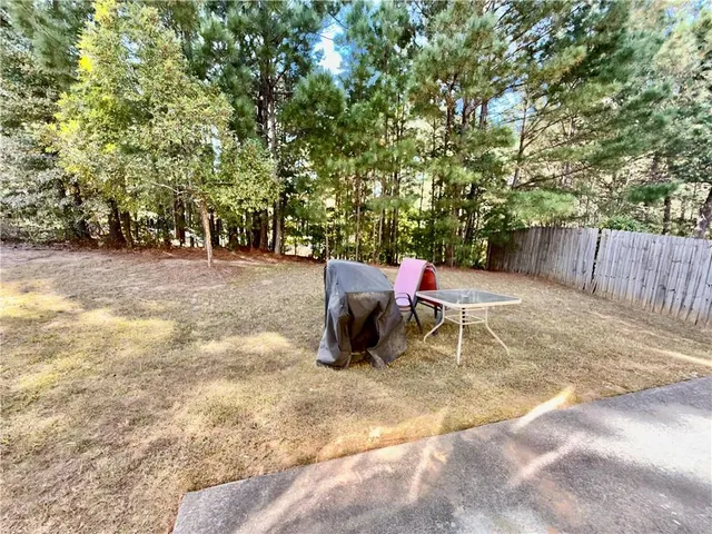 a backyard of a house with table and chairs