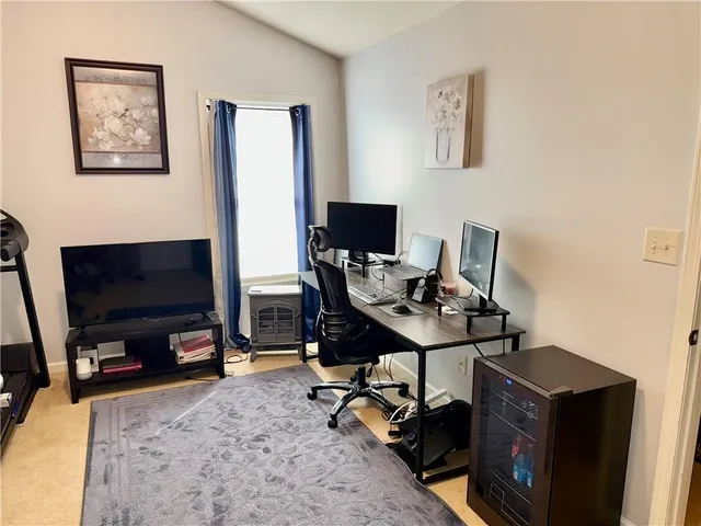 a view of a workspace with furniture and a flat screen tv