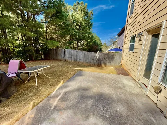 a backyard of a house with table and chairs
